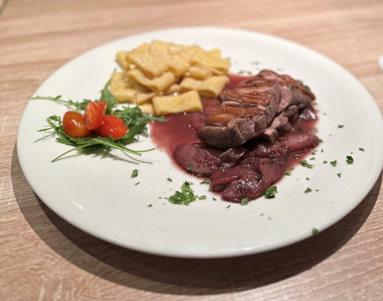 Rosa gebratenes Rinderfilet an Rotweinsauce mit grünen Bohnen und Gnocchi