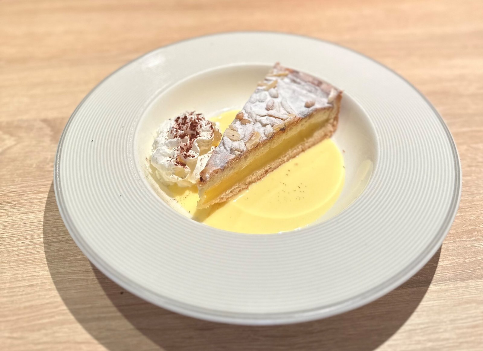 Zitronentarte mit Puderzucker, Vanillesauce und Sahne