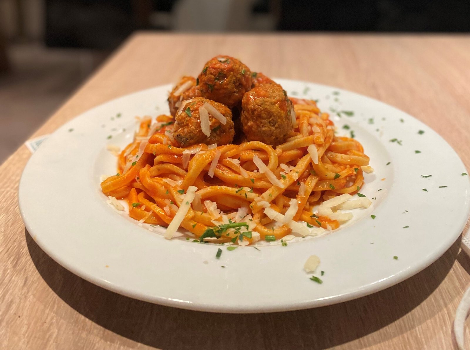 Spaghetti mit Tomatensauce und Fleischbällchen, bestreut mit Parmesan