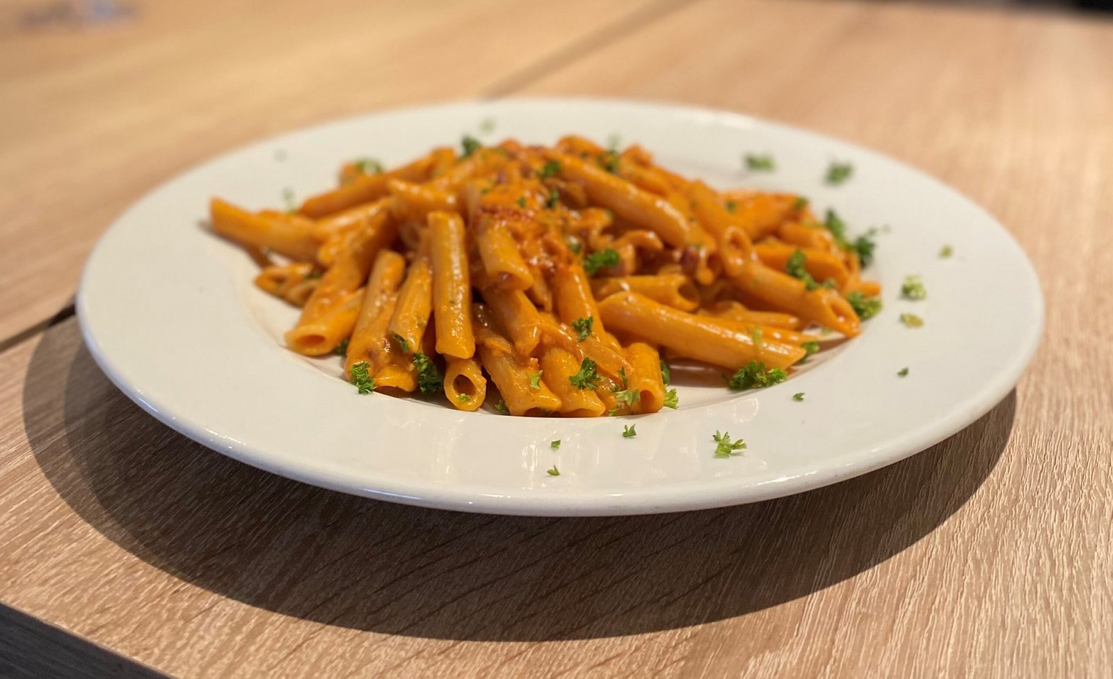 Penne mit pikanter Tomatensauce, garniert mit frischen Kräutern